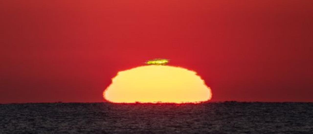 El &quot;rayo verde&quot; sobre el sol en una playa ilicitana durante el amanecer del pasado domingo.