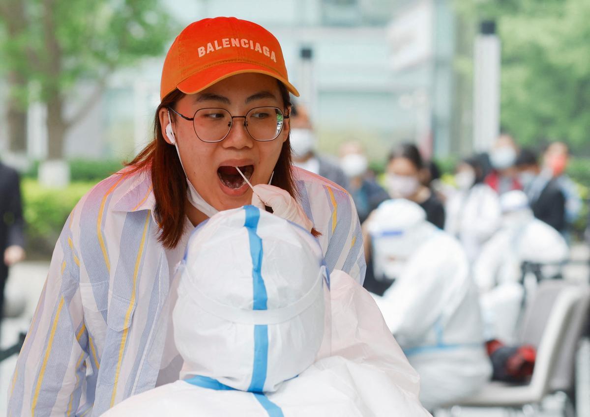 Una mujer se hace una PCR para comprobar si tiene el coronavirus, en una carpa médica instalada en las calles de Pekín.