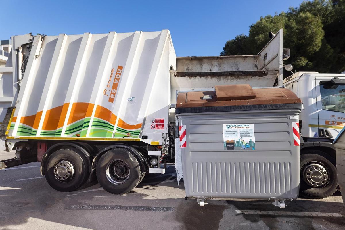 Un camión de recogida de residuos de El Campello, ante un contenedor marrón