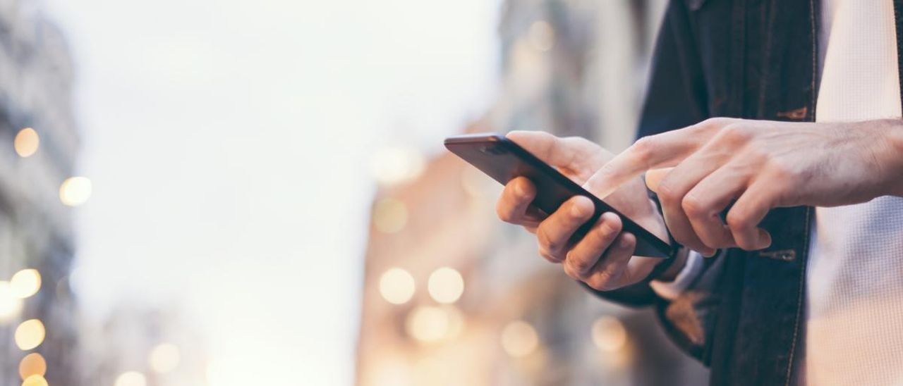 Un hombre consulta su teléfono móvil.