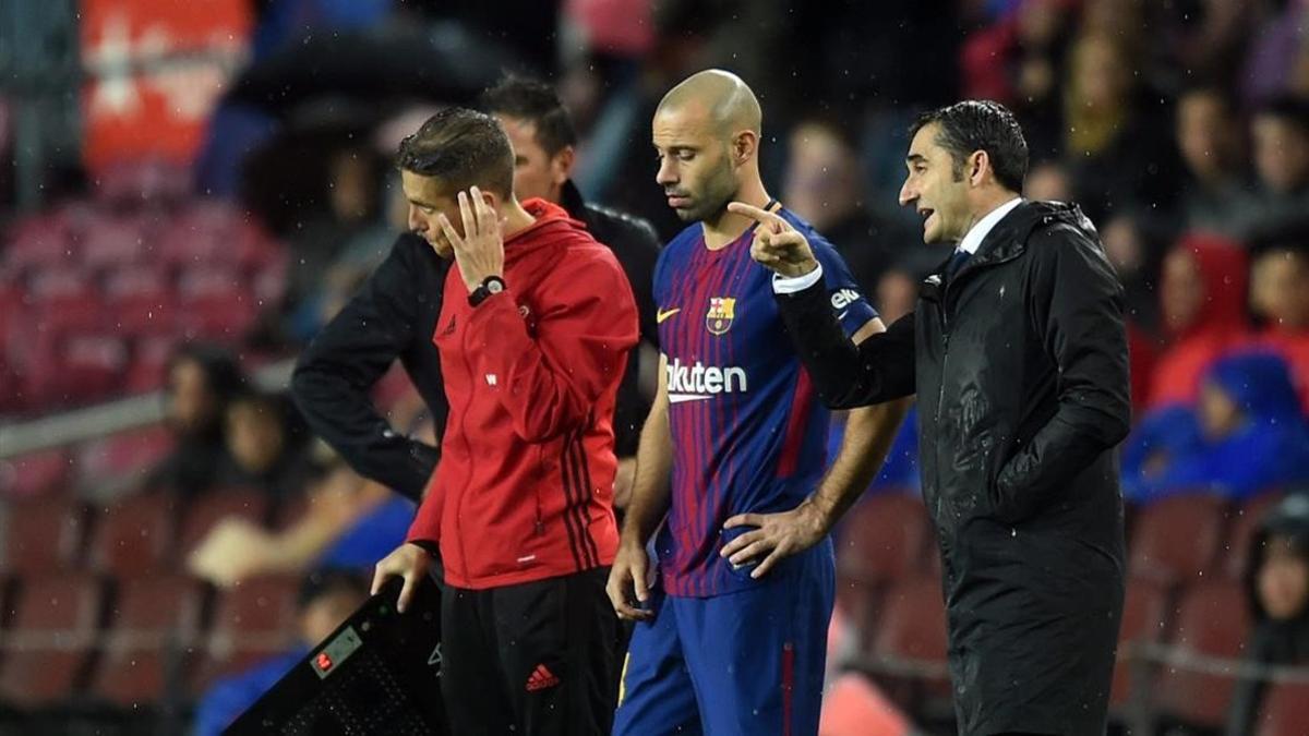 Valverde da instrucciones a Mascherano antes de que entre en juego.