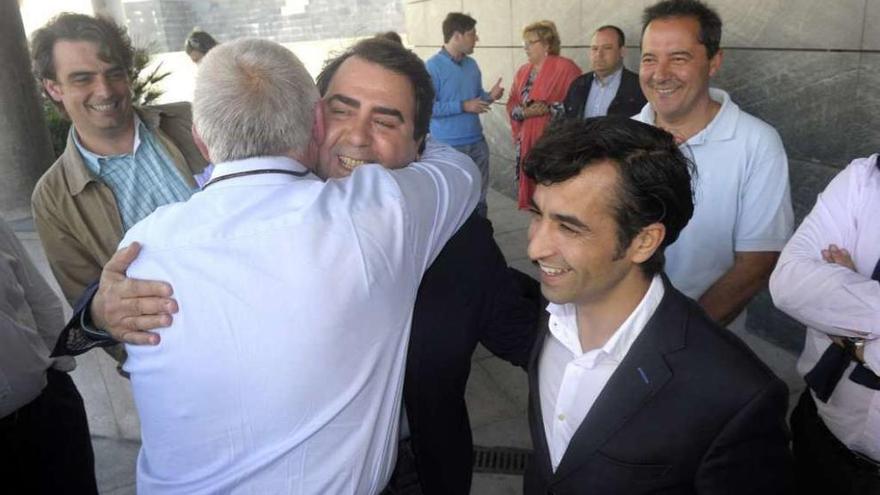 Un militante abraza a Negreira, entre Diego Calvo y Rey Varela, en una junta en junio.