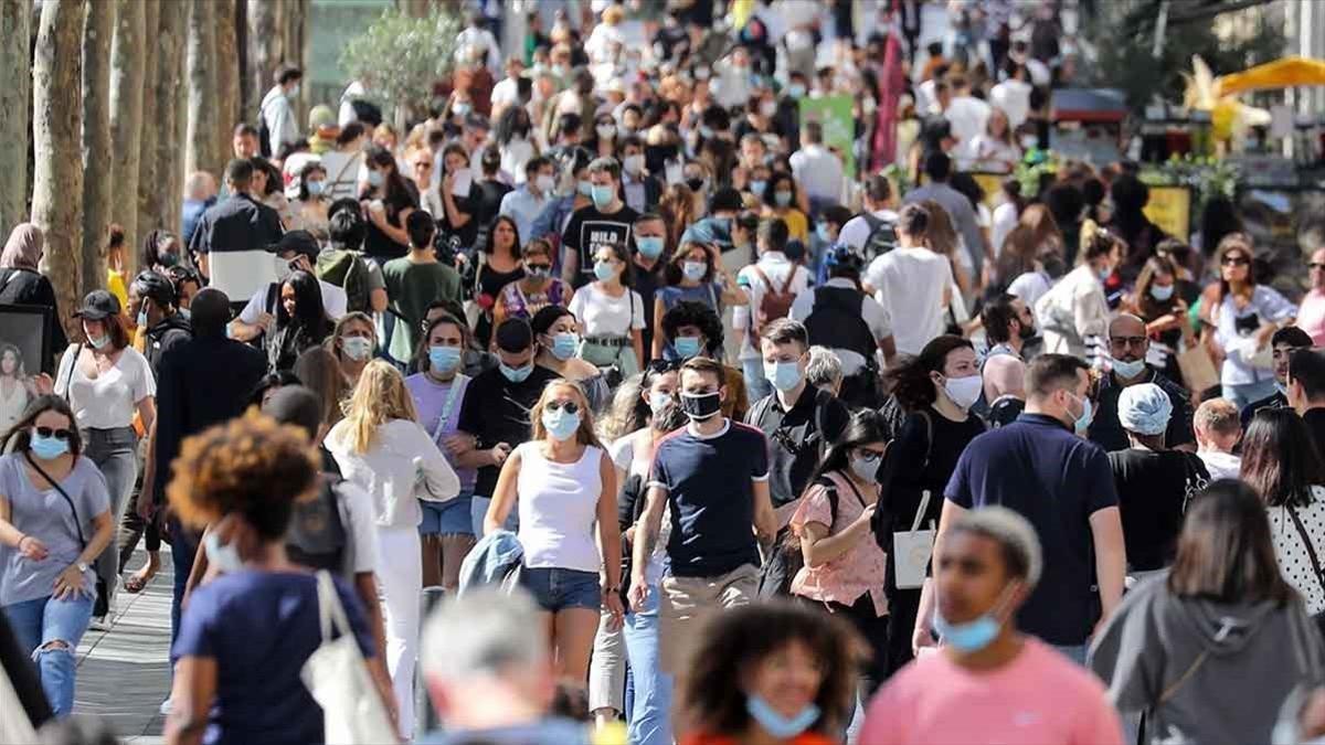 Personas con mascarillas pasean por la Avenida de los Campos Elíseos en París