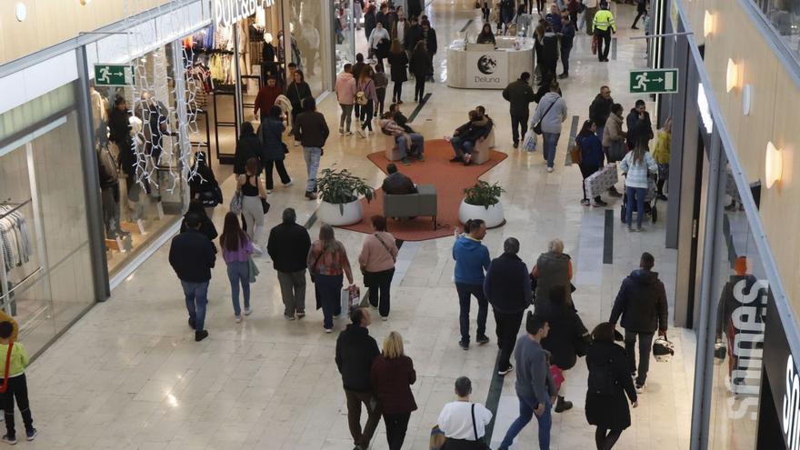 Varias personas en el centro comercial Puerto Venecia, ayer, que abrió el festivo.  | ANDREAA VORNICU