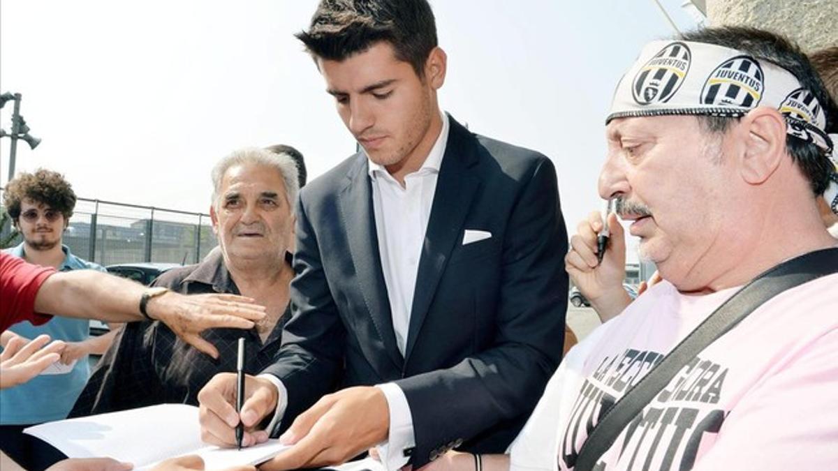 Morata firma autógrafos a los aficionados de la Juventus en Turín.