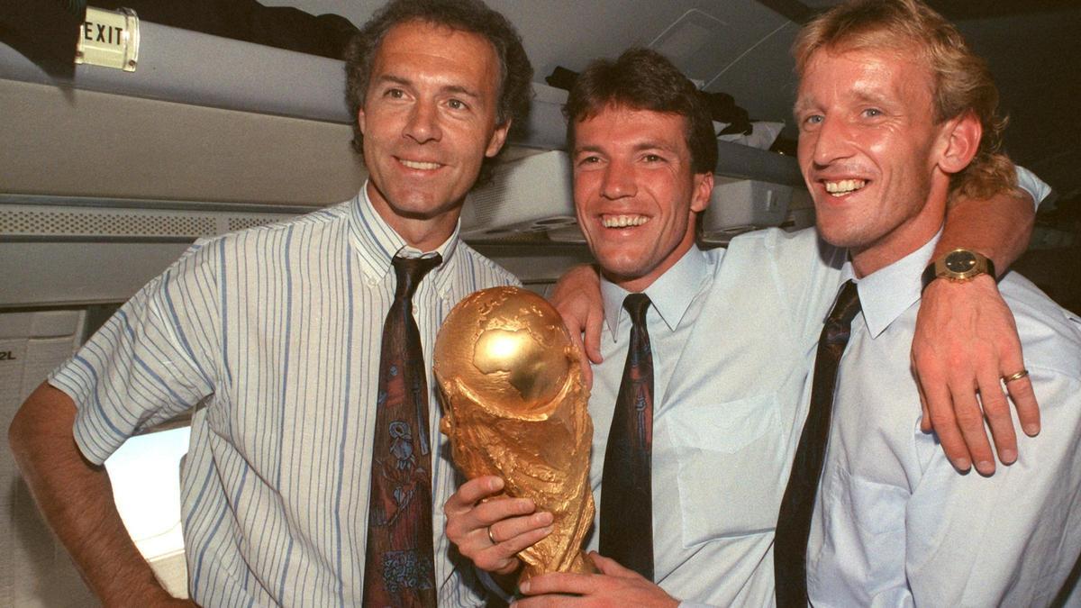 Franz Beckenbauer, el seleccionador de Alemania, con Lothar Matthäus, el capitán, y el defensa Andreas Brehme, autor del gol que dio a Alemania el título mundial en 1990.  ent the World Cup trophy. Photo: Wolfgang Eilmes/dpa
