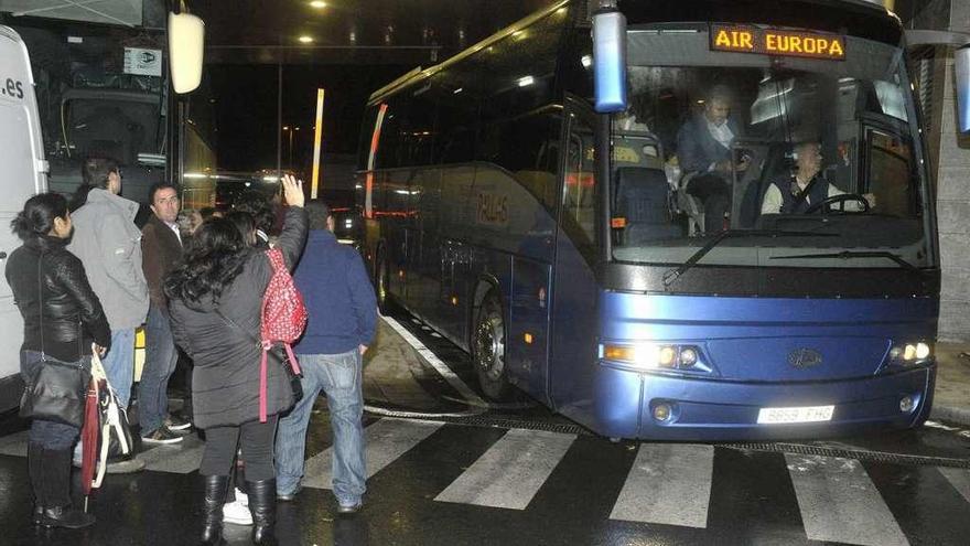 Un bus recoge pasajeros en Alvedro por el desvío de un avión a Lavacolla en 2004.