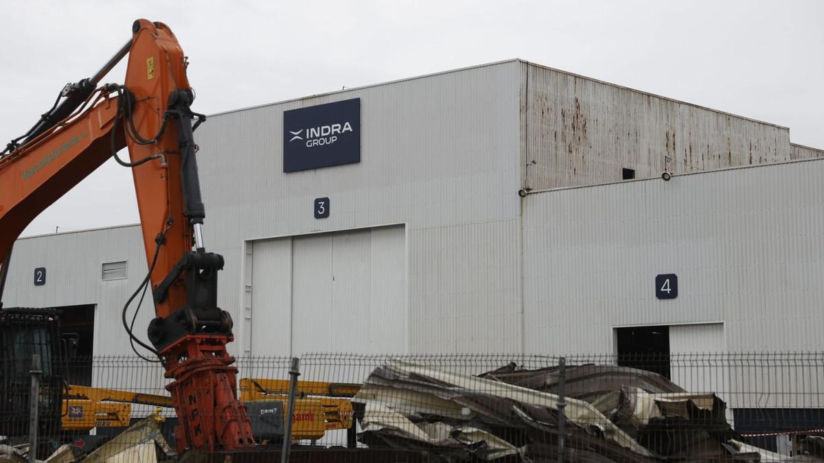 Obres de reforma nel Tallerón de Xixón, yá col logo d'Indra na fachada.