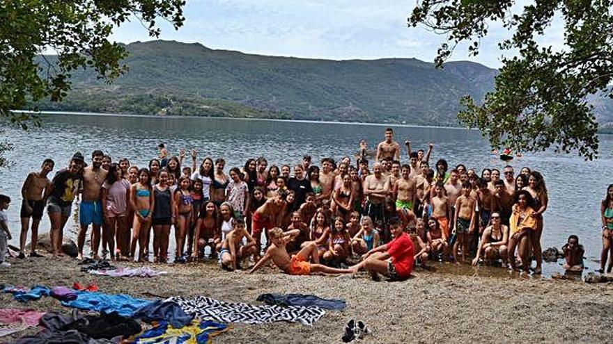 Niños, jóvenes, monitores y el padre Francisco Díez posan en las márgenes del Lago de Sanabria.