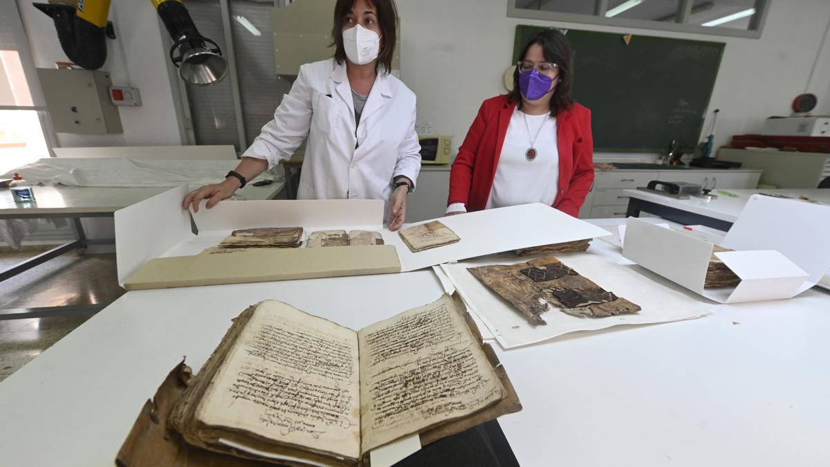La técnico de restauración de documentación gráfica, Mónica Pintado, junto a la diputada de Cultura de Castelón, Ruth Sanz, observando documentos antiguos del archivo de Zucaina.