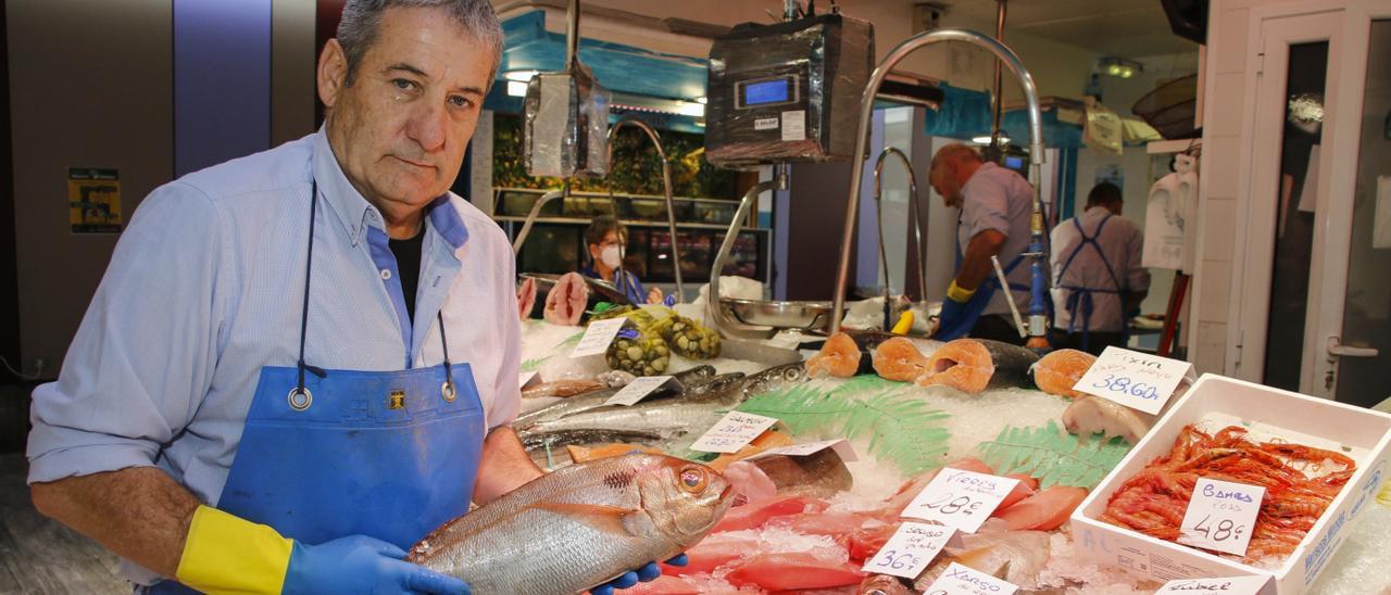 El pescadero avilesino Vicente Rodríguez coloca piezas de pescado en el mostrador de su establecimiento.