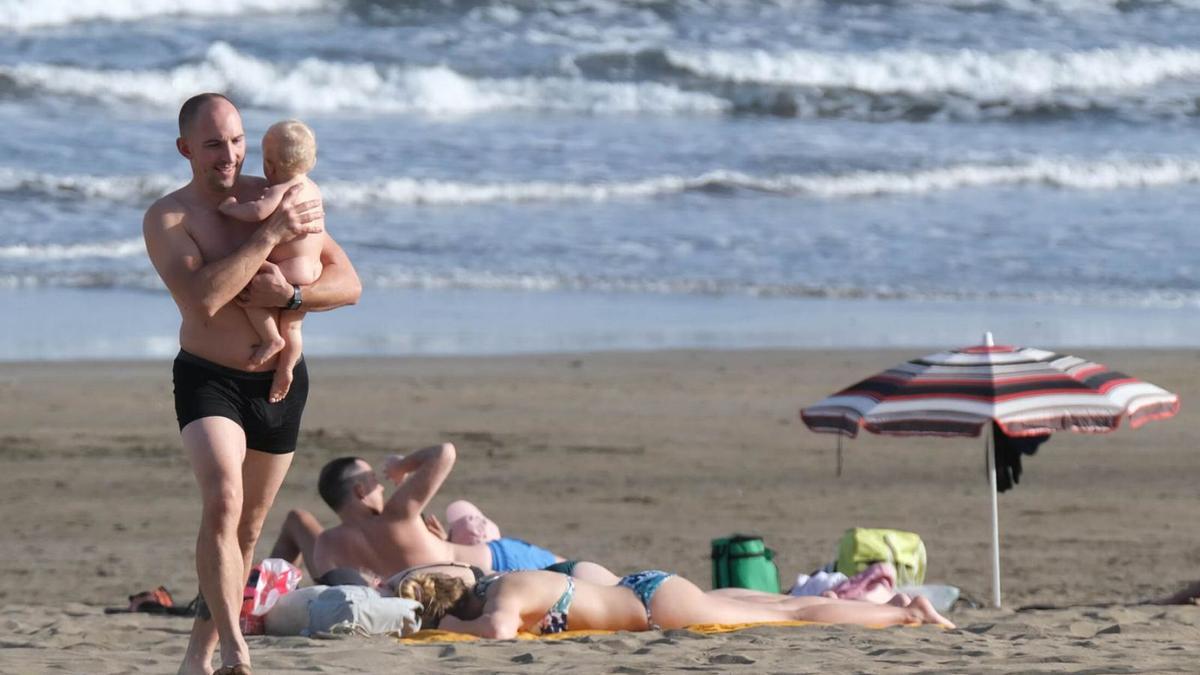 Grupos de turistas disfrutan de una playa del sur de Gran Canaria .