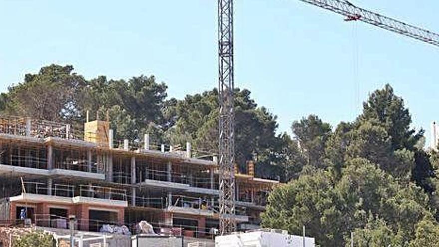 Una grúa de construcción en las obras de una promoción de viviendas en Cala Vedella.