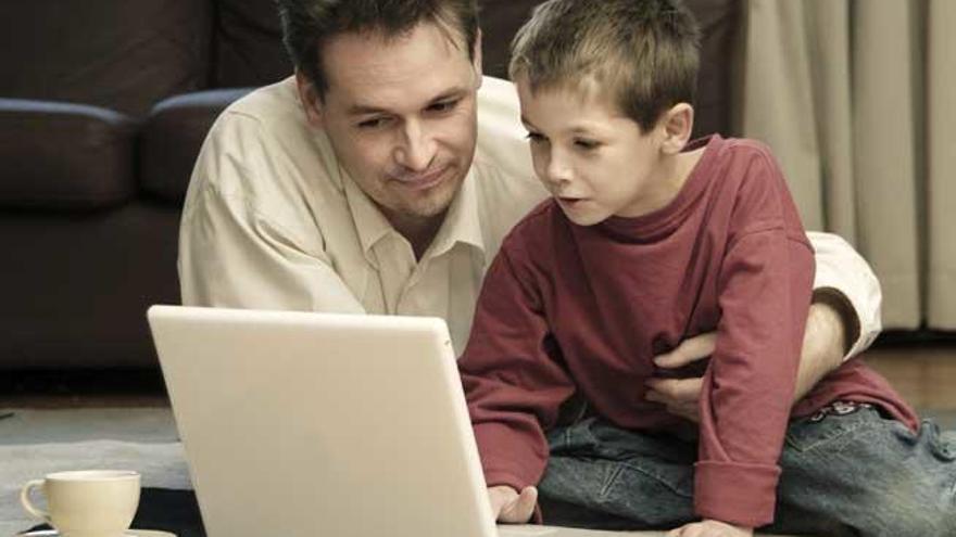 Un padre y su hijo, ante un ordenador.