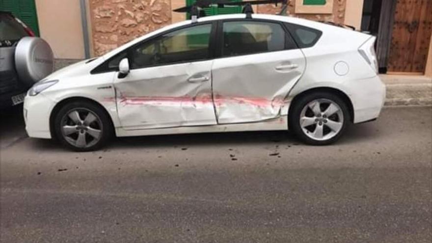 Un coche estacionado en PÃ²rtol con graves abolladuras en su carrocerÃ­a y restos de pintura roja.