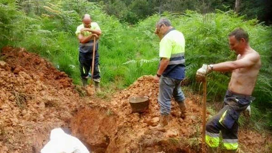 Tres operarios del servicio municipal de Obras trabajan reparando la tubería de Arriondas.