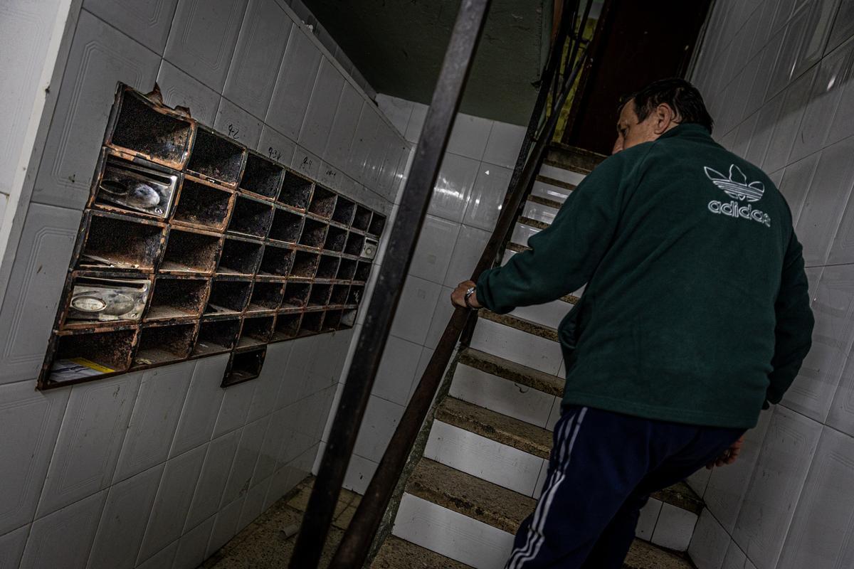 Un vecino del bloque de la calle Venus, en el barrio de La Mina, observa unos buzones destrozados.