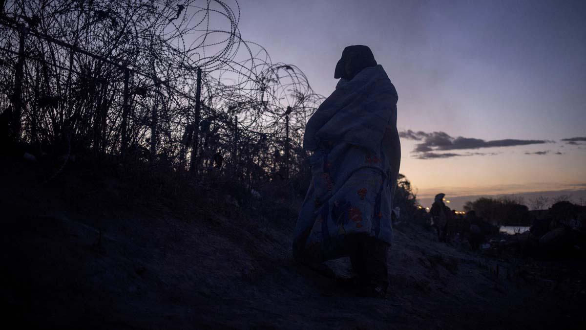 Migrantes acampan a lo largo de la orilla del río Grande mientras esperan entregarse a las autoridades de inmigración en El Paso, Texas, EE.UU