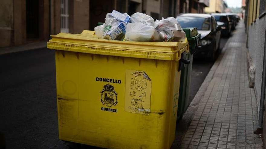 Contenedor rebosante de bolsas de basura en la calle Alejandro Pedrosa, en O Vinteún. // Brais Lorenzo