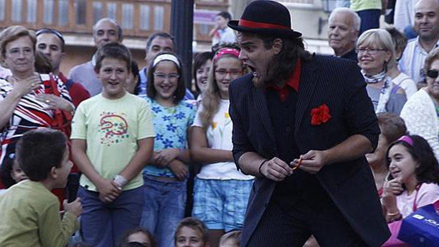 El mago Carlos Adriano bromea con un niño.