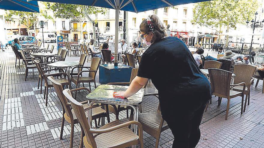 Una camarera desinfecta una mesa en Zaragoza.