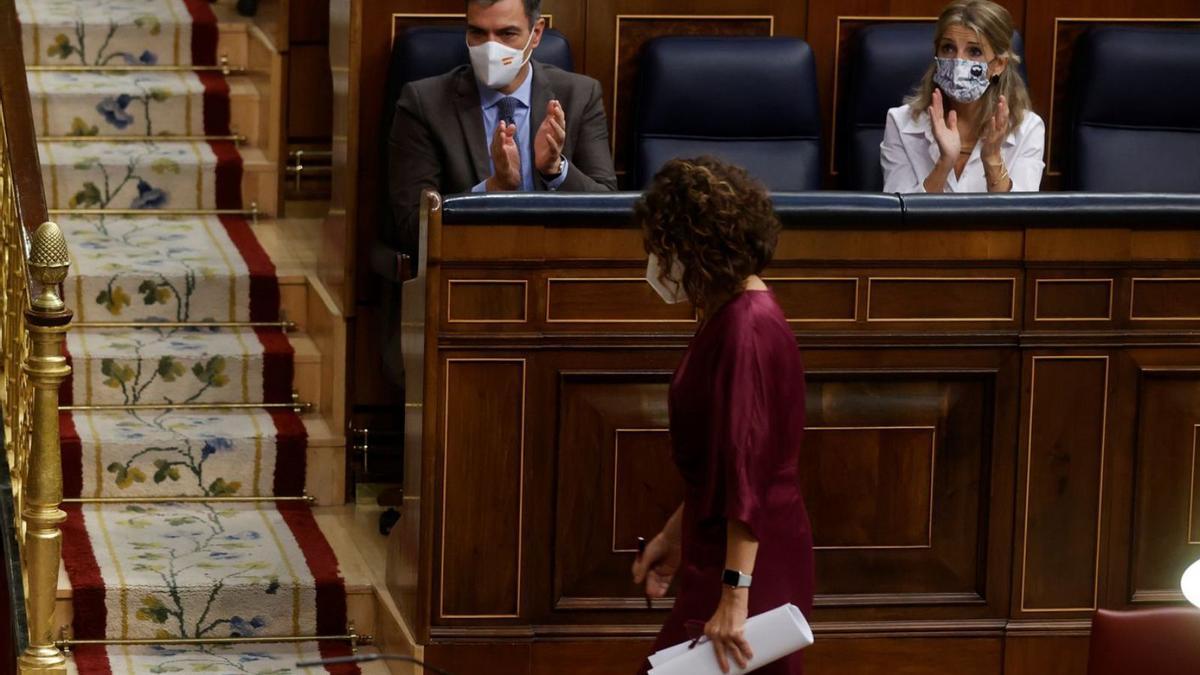 Montero camina cap al seu escó mentre Sánchez i Díaz l’aplaudeixen