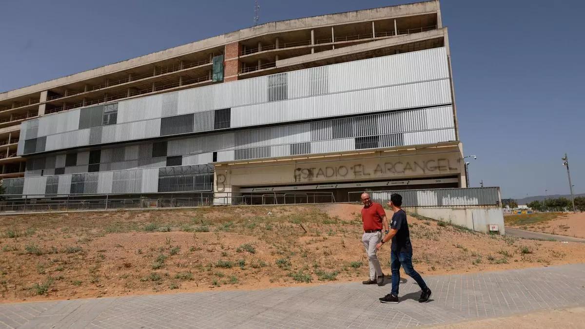 Dos personas caminan junto al estadio El Arcángel, donde podría ubicarse la sede del futuro organismo de investigación de accidentes.