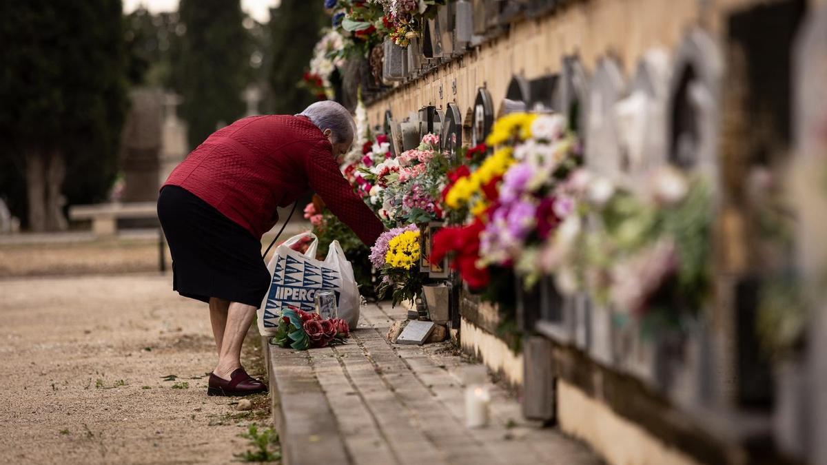 Una mujer deja flores en un nicho del cementerio de Torrero, en una imagen de archivo.