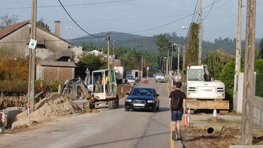 Los operarios trabajan en la construcción de los muros de las fincas, ayer, en la carretera en Vilar.