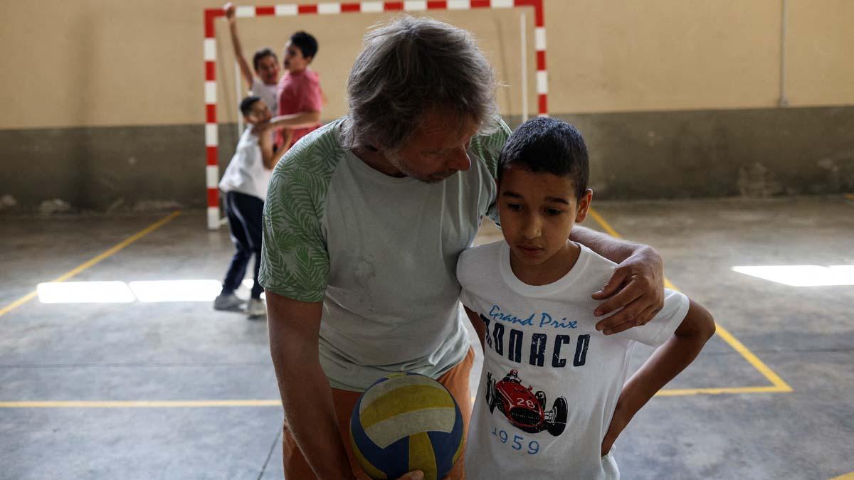 Alberto Toro consuela a Achraf Labriyaj, de 9 años, tras perder en un partido de fútbol mientras su hermano Ismael Labriyaj, de 12, Youssef el Hadri, de 9, y Eloy Moliner, de 12, celebran durante el recreo en su colegio de Pitarque, Teruel, uno de los menos poblados regiones de la Unión Europea, 13 de junio de 2022. “Los voy a extrañar mucho, pero me mantendré en contacto. Nos hemos convertido en una familia, así deben ser los centros educativos, sin importar su tamaño”, dice Toro.