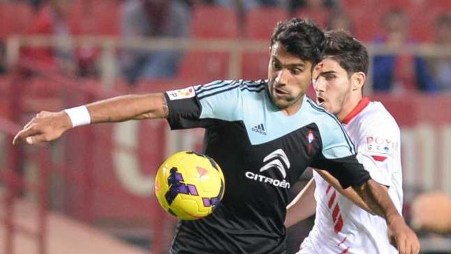 Augusto Fernández pugna por el balón con un jugador del Sevilla, ayer, en el Sánchez Pizjuán. // LOV