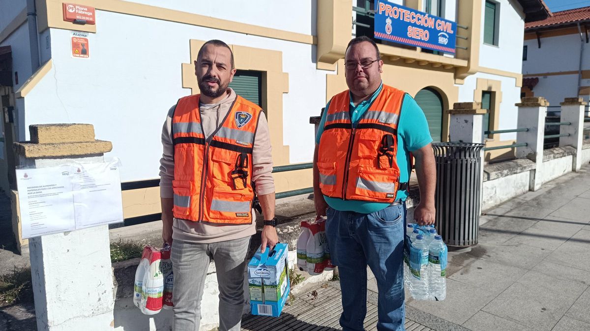 Por la izquierda, Juan Sierra y Manuel Velasco, durante la recogida de donaciones en la sede de Protección Civil de Pola de Siero.