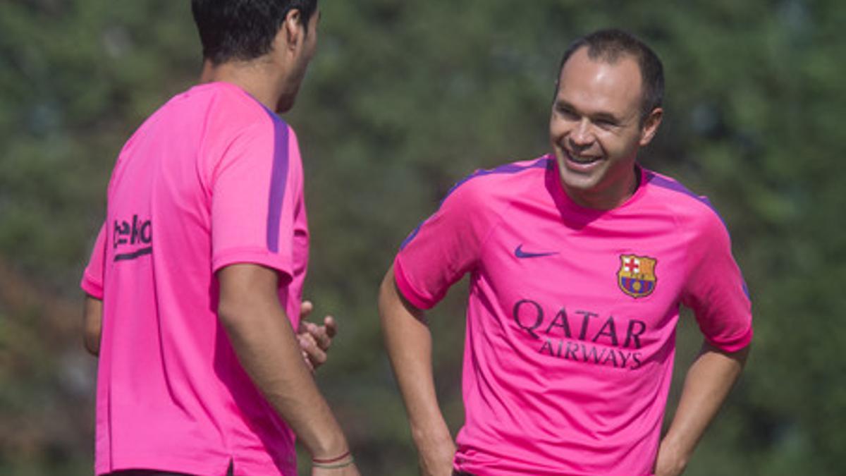 Iniesta sonrie durante su charla con Suarez  en el campo de la ciutat esportiva para la sesion de entrenamiento.