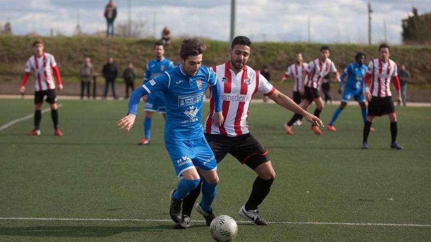 Noel intenta proteger la bola ante Cristian.