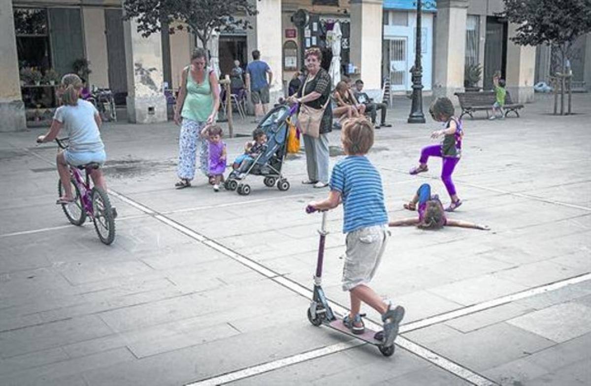 Uns nens juguen a la plaça de Masadas, al barri de la Sagrera, ahir.