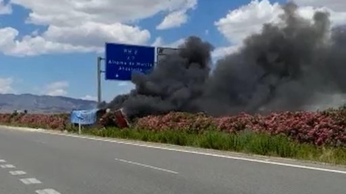 Camión descarrilado en llamas.