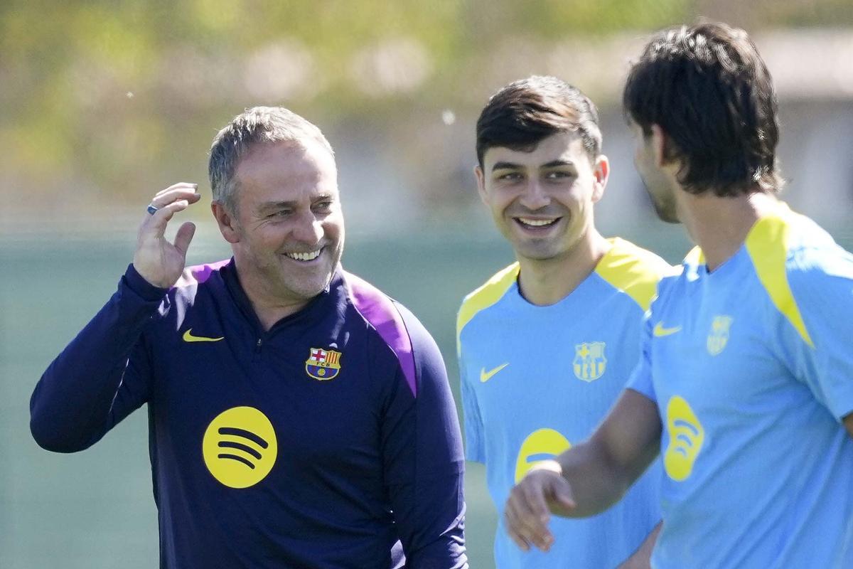 Hansi Flick bromea con Ferrán Torres y Pedri González, durante el entrenamiento de este martes.