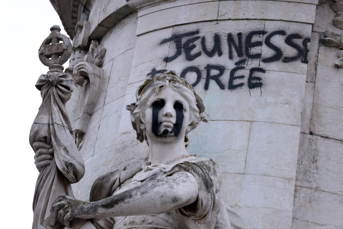 La estata de la Igualdad con lágrimas negras pintadas en los ojos y un grafiti en el que se lee 'Juventud dorada', en el Monumento a la República en la homónima plaza parisina, epicentro de las protestas estudiantiles.