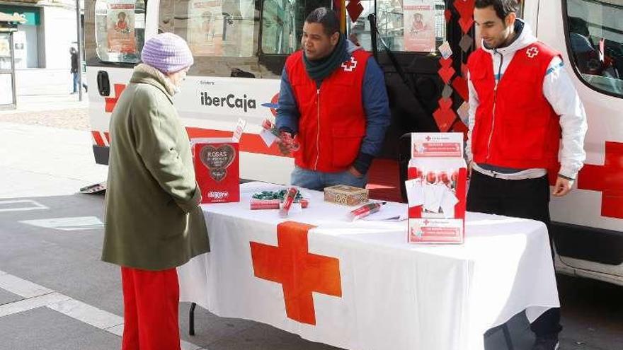 Voluntarios de Cruz Roja ofrecen flores de chocolate.