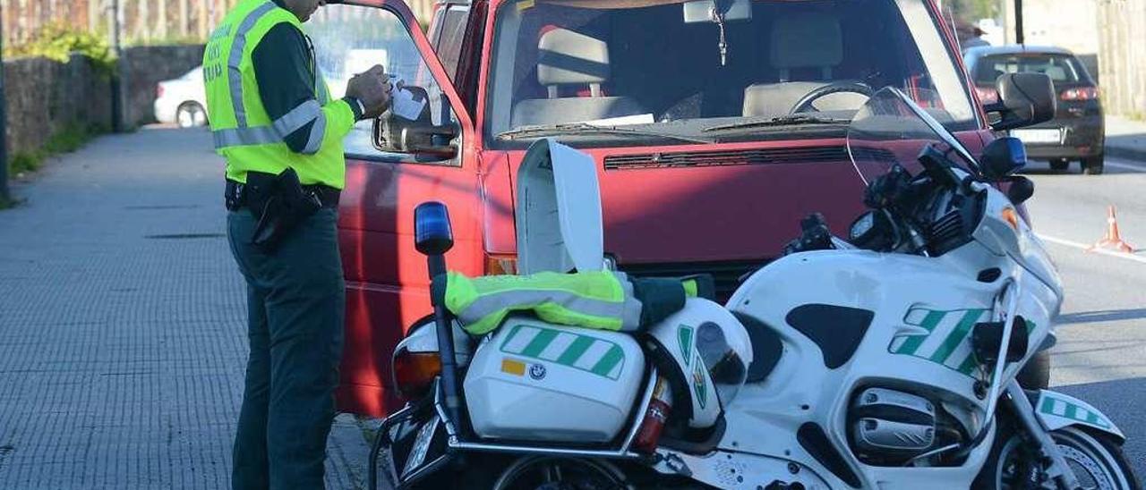 Un agente de la Guardia Civil de Tráfico impone una multa en una carretera pontevedresa. // Rafa Vázquez