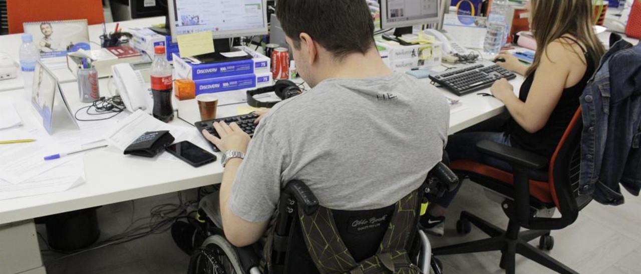 Un trabajador con diversidad funcional, en su puesto de trabajo.