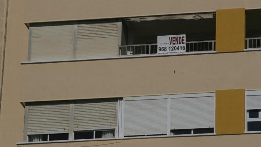 Un cartel indica que hay un piso en venta, en un edificio próximo al centro histórico de la ciudad