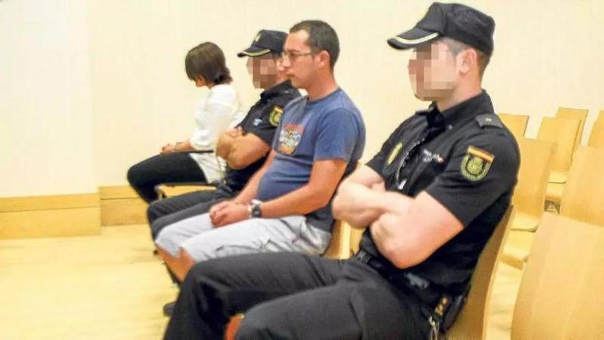 Óscar Jesús A. G., entre dos agentes de la Policía Nacional, en el banquillo en su juicio en Elche.