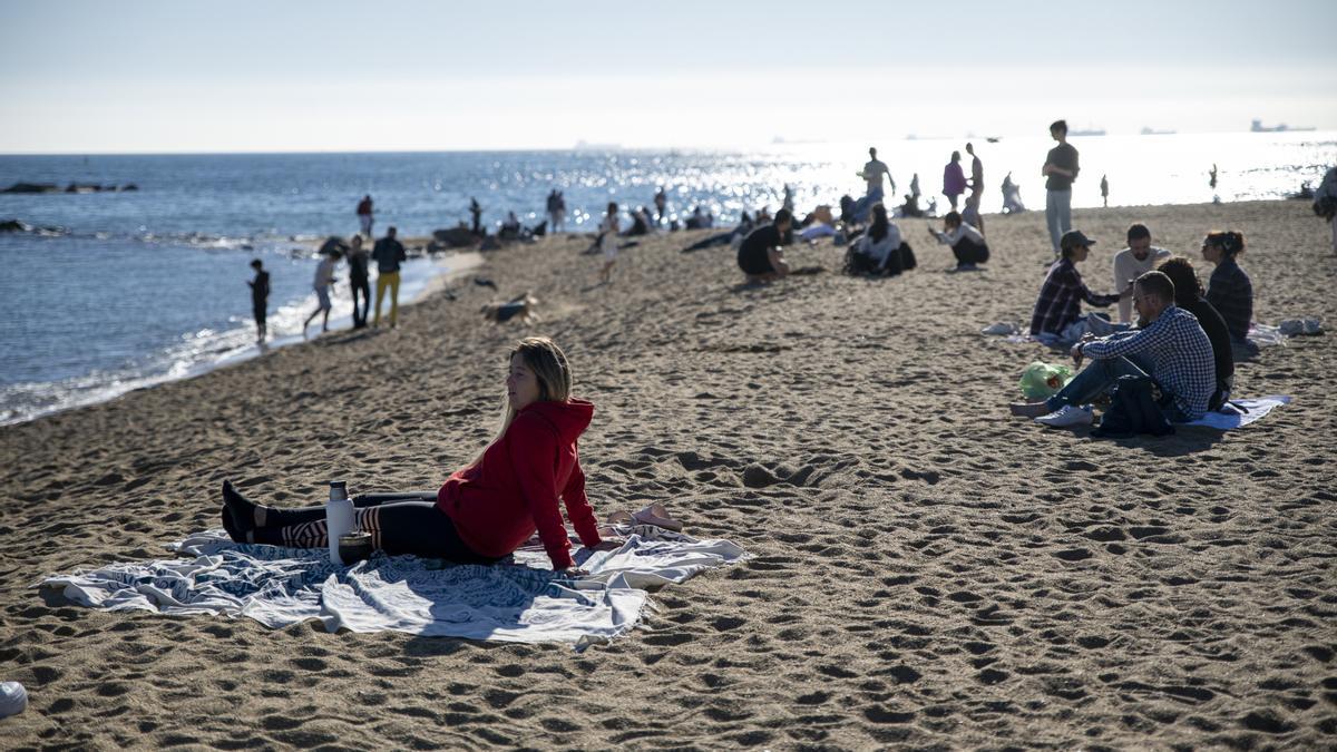 Varias personas disfrutan del sol y el calor en la playa de la Barceloneta, a 25 de diciembre de 2022, en Barcelona, Cataluña (España).