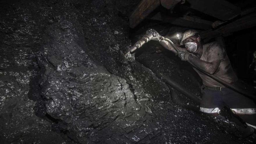 Un minero pica carbón en un pozo de Hunosa.