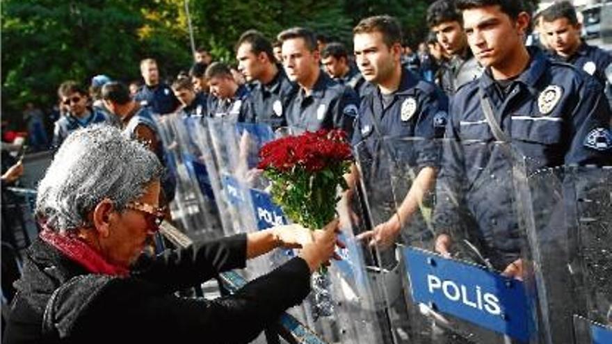 Una dona lliura un ram de flors als agents de la policia turca, ahir a Ankara.