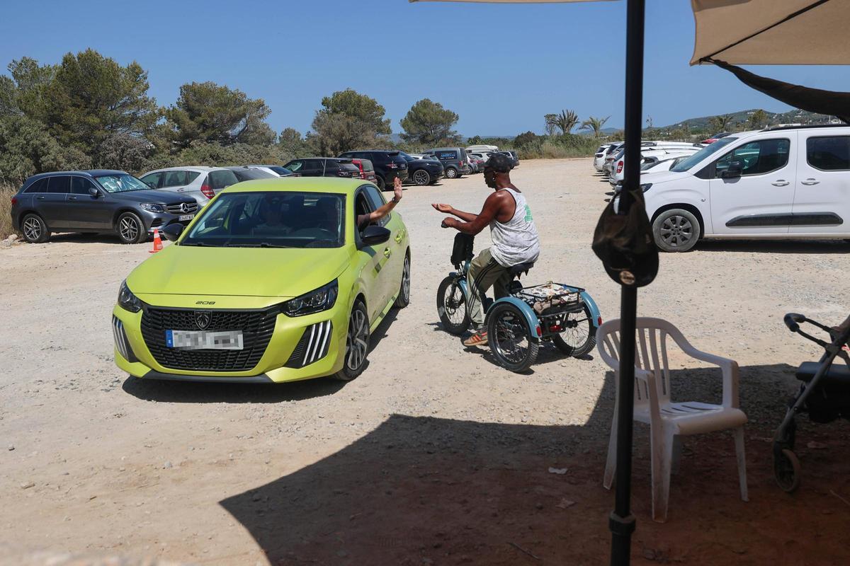 El trabajador pide una propina a uno de los visitantes de la playa