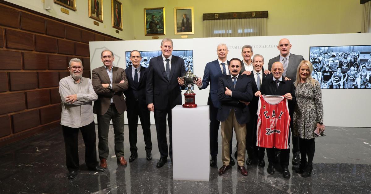 La plantilla que consiguió la Copa del Rey de 1983 posa junto a Félix Brocate y la camiseta del CAI Zaragoza que le han entregado en el Ayuntamiento de Zaragoza.