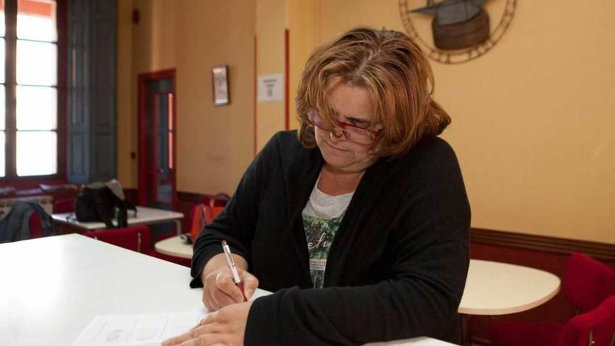 La edil Sara Alonso consulta el documento en el que se recogen las firmas, ayer, en la Casa del Pueblo de Pola de Laviana.