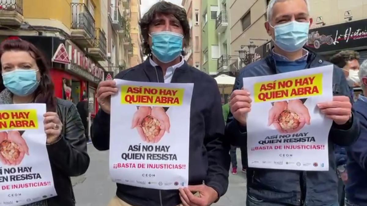 Pegada de carteles en el centro de Alicante para reclamar que se levanten las restricciones a la hostelería